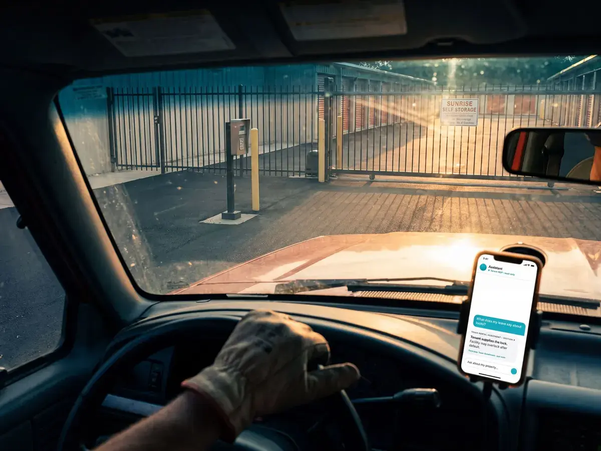 Operator pulling up to a storage facility gate with Tenant MCP open on a dash-mounted phone